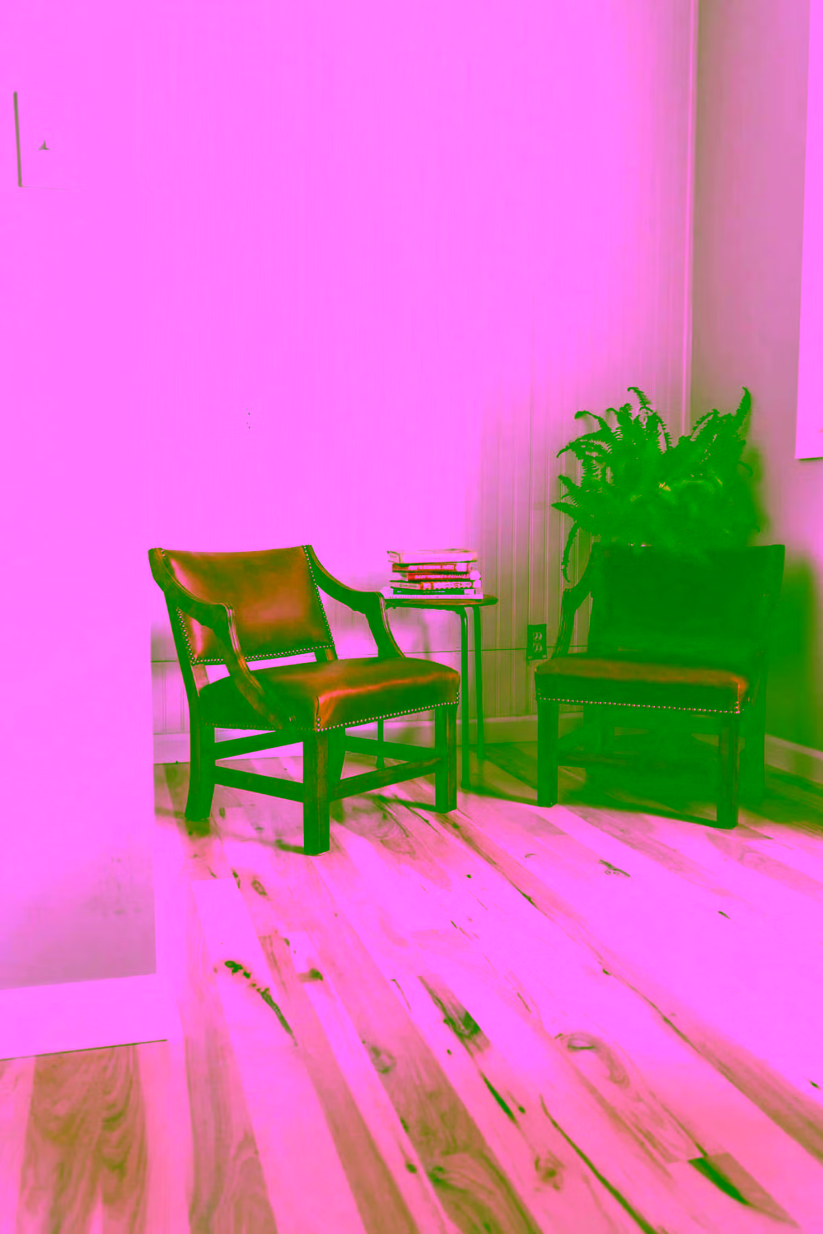 Reading nook with two leather chairs on light hickory floors